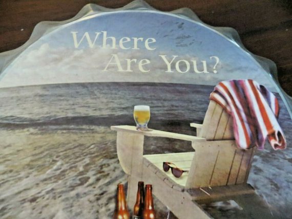 high-tide-beer-bottle-cap-tin-bar-sign-chair-on-the-beach-sand-on-ocean